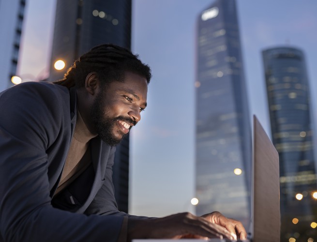 businessman with laptop at night buildings Photo chantier